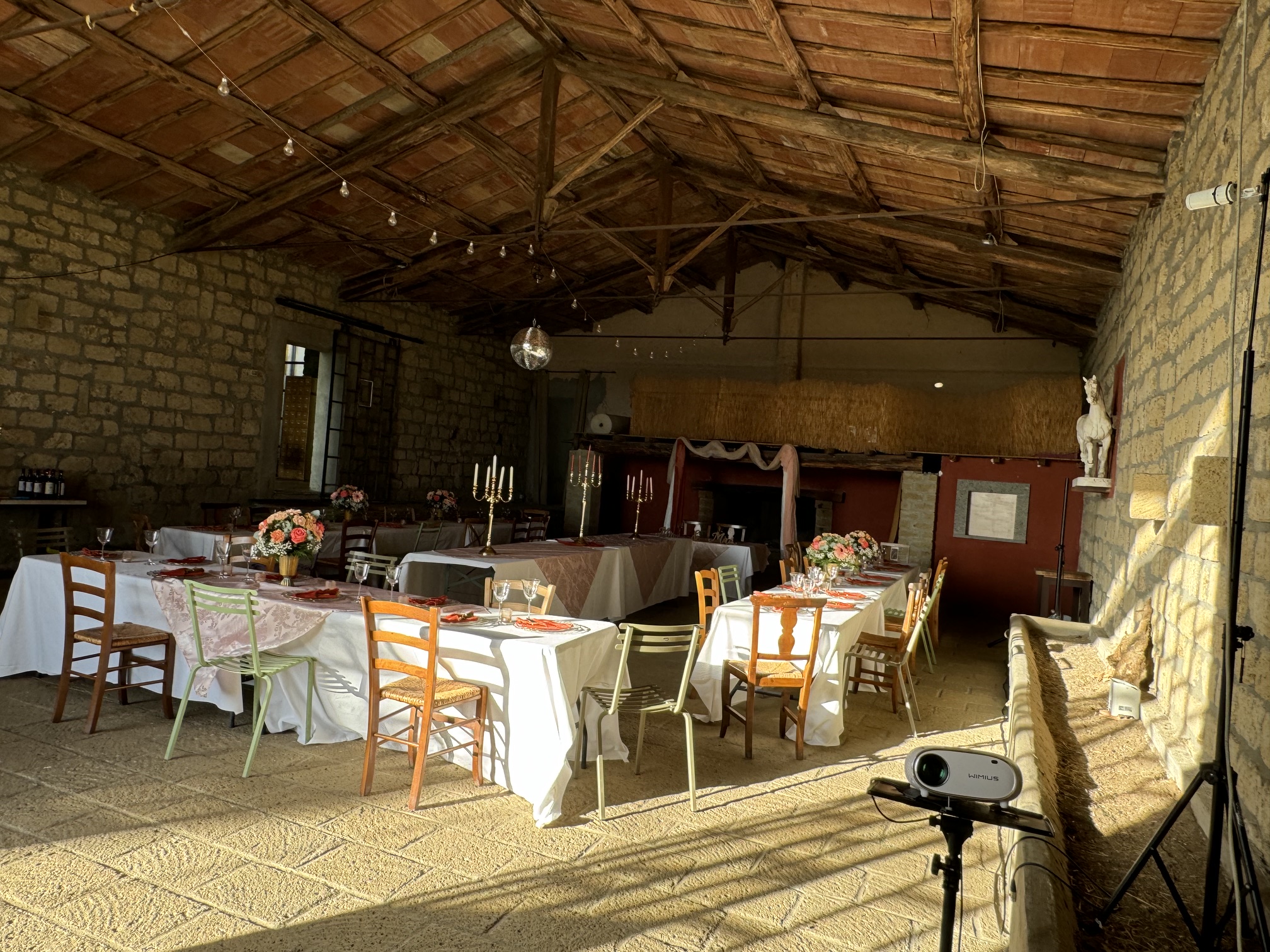 Stone reception barn set with dining tables and string lights